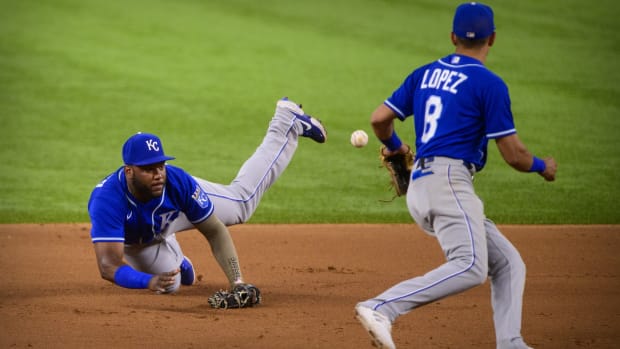 Jun 26, 2021; Arlington, Texas, USA; Kansas City Royals second baseman Hanser Alberto (49) misplays a throw to shortstop Nicky Lopez (8) during the eighth inning against the Texas Rangers at Globe Life Field. Mandatory Credit: Jerome Miron-USA TODAY Sports